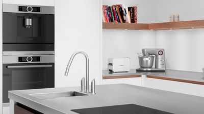 Modern kitchen design featuring built-in appliances, a sleek faucet, and a stylish countertop