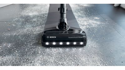 A vacuum cleaner with a dusting brush on the til floor, ready to tackle the cleaning tasks.