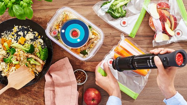 Vidéo d'un mixeur plongeant conditionnant sous vide des aliments dans des sacs et boîtes de conservation.