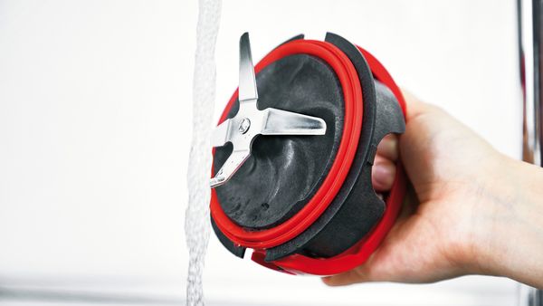 The knife of a BOSCH blender gets cleaned under water.