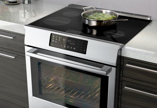 Bosch induction range with food on cooktop.