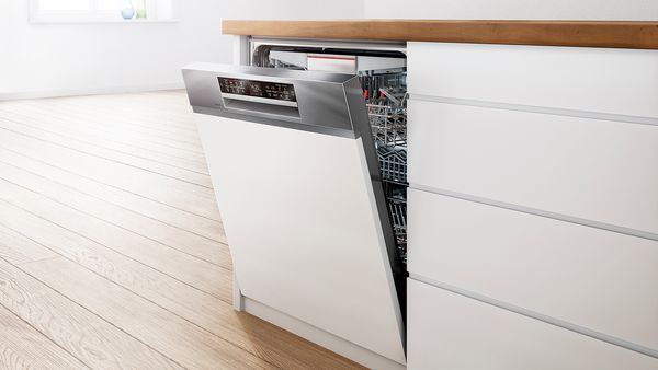 Vaatwasser geïnstalleerd onder houten aanrecht in moderne keuken interieur.
