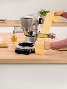 Koffiemolen, olijfolie, houten tafel, handen operatieapparaat.