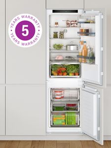 Open fridge with fresh produce, drinks and a neatly organised interior, with a 5 year warranty sticker. 