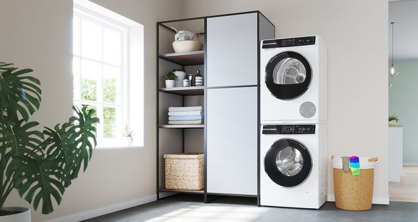 Een wasmachine en droogautomaat op elkaar in een kleedruimte.