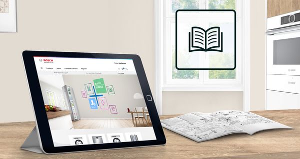 Tablette affichant un site Web d'appareils électroménagers, un livre ouvert et des appareils de cuisine dans un intérieur de maison moderne.