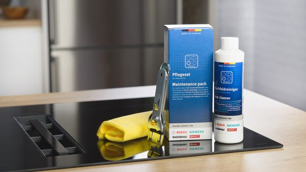 Maintenance pack and cleaning products for kitchen appliances on a countertop beside a cloth. 