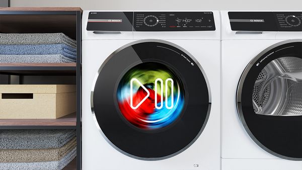 washing machine and tumble dryer next to each with a pause symbol