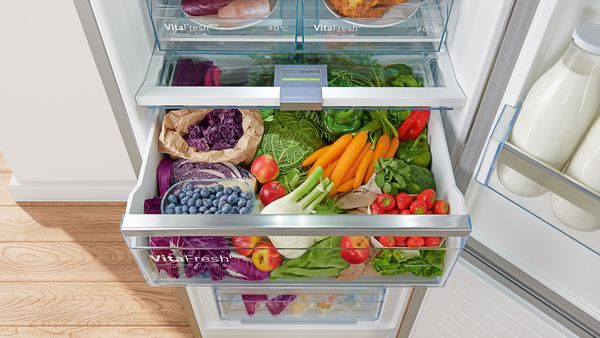 A close-up of an open fridge with the VitaFresh drawer pulled out to reveal lots of fresh fruit and vegetables.