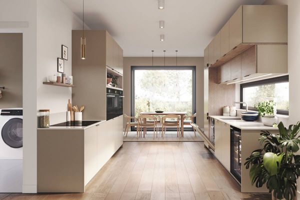 Koloniaalblauwe, parallelle keuken met ingebouwde apparatuur en een volledig verlichte glazen buitendeur aan het eind