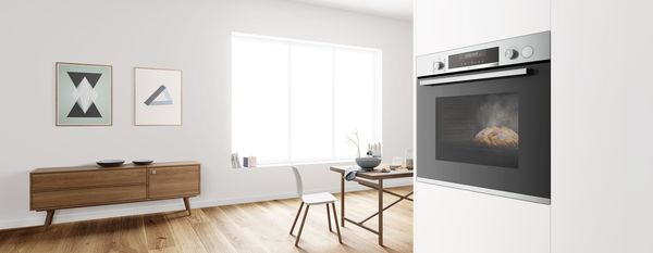Modern minimalist kitchen with wooden furniture, artwork, and large window. 