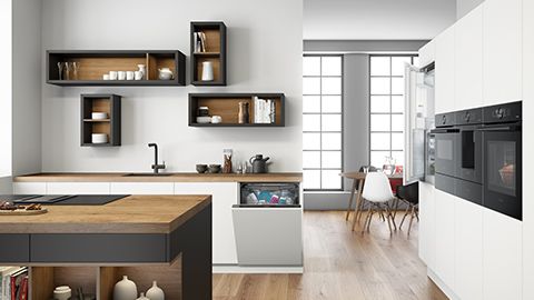 Moderne keuken met houten aanrecht, planken en apparaten in een lichte, open-concept ruimte.